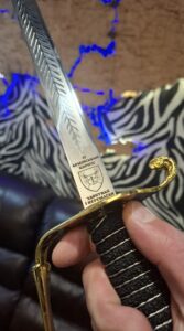 Гравіювання на шаблі — лазерне нанесення герба, девізу та напису «12 Армійський корпус. Здобувай і перемагай» на клинку